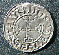 Silver penny of King Edward the Confessor. This example was minted in Thetford by Estmund between 1053 and 1066. The date is shown by the pointed helmet pattern on the obverse shown above at 1044.